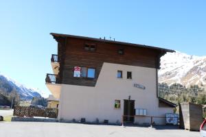 a white building with a wooden roof at Apartment Chez Véro et Bernard in Bourg-Saint-Pierre