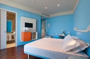 a blue bedroom with a white bed and a blue wall at JR Hotels Bari Grande Albergo delle Nazioni in Bari