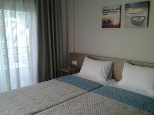 a bed in a hotel room with a window at Lola's Hotel in Platanias