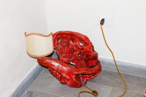 a red glass sculpture sitting next to a toilet at B&B Il Castello in Castiglion Fibocchi