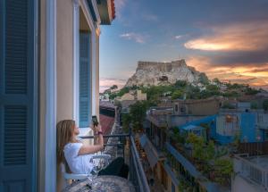 a woman sitting on a balcony looking out a window at Palladian Home in Athens