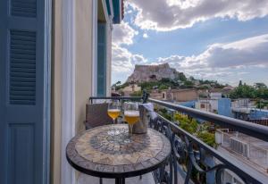 a table with two glasses of wine on a balcony at Palladian Home in Athens