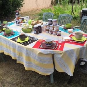 Chez Cathy في LʼHoumeau: طاولة عليها طعام وجارات