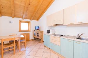 a kitchen with blue cabinets and a table and a dining room at Bait Del Pont in Livigno