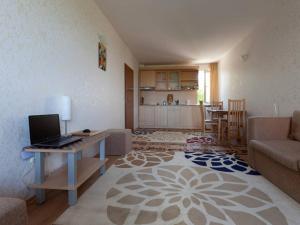 Una sala de estar con un sofá y una mesa con una computadora portátil. en Panoramic Sea View Apartment, en Ravda
