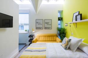 a bedroom with a yellow couch and a yellow wall at Urban Suite Santander in Santander