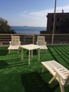 three white benches and a table and two chairs at Gaslini vicinissimo - Casa dello Zio in Genoa