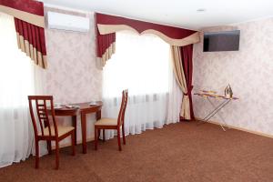ArtemivsʼkにあるHotel Bakhmutのテーブルと椅子、テレビが備わる客室です。