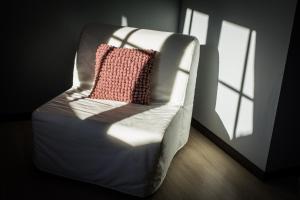 - Silla blanca con almohada rosa en la habitación en L'Envolée, en Chiny