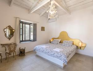 a bedroom with a bed and a chandelier at Villa Sunrise in Hydra
