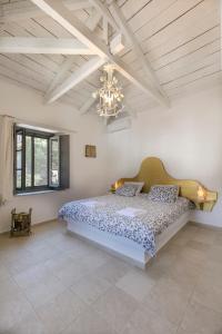 a bedroom with a bed and a chandelier at Villa Sunrise in Hydra