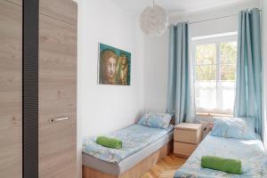 a bedroom with two twin beds and a window at Evva & Peppe Old Town Flat in Warsaw