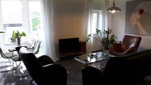 a living room with chairs and a table and a tv at Vilnius Luxury Apartment 1 in Vilnius