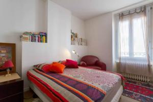 a bedroom with a bed and a chair and a window at T3 55m2 & Garage, proche Saône, et 5 min Vieux Lyon via Metro D in Lyon