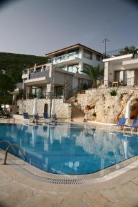 a large swimming pool in front of a building at Kulube Hotel in Kalkan