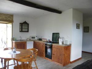 a kitchen with a table and a kitchen with a table and chairs at Pear Tree Gite in Génis