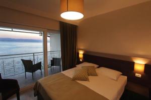 a hotel room with a bed and a balcony at Hotel Stanger in Lovran
