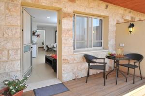 a balcony with a table and chairs in a room at Berale in Kefar Qish