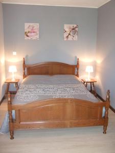 a bedroom with a wooden bed with two lamps at L'Envolée in Chiny