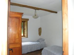Habitación con dormitorio con 2 camas y puerta. en Pear Tree Gite en Génis