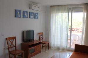 a living room with a tv and a table and chairs at Apartamentos Turisticos Caños de Meca in Los Caños de Meca