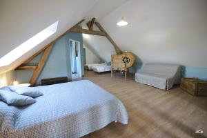 een slaapkamer met 2 bedden en een zolder bij Chambres d'hôtes Ferme du Feugrès in Saint Germain la campagne