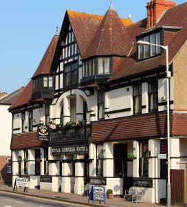 een zwart-wit gebouw op de hoek van een straat bij The Royal Norfolk Hotel in Folkestone