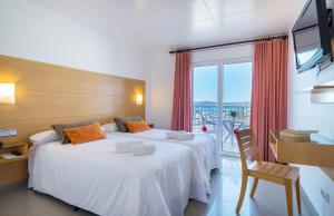 a hotel room with two beds and a balcony at Hotel & Diving Les Illes in L'Estartit