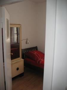 Schlafzimmer mit einem roten Bett und einem Spiegel in der Unterkunft Ferienwohnung Westend-Grunewald in Berlin
