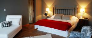 薩爾塔的住宿－卡拉精品酒店，卧室配有红色和白色的床和沙发