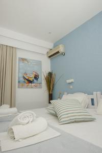a bedroom with two beds and a painting on the wall at Nissos Poros in Poros