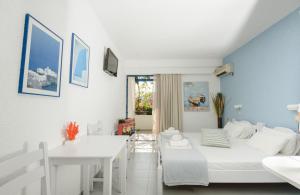 a bedroom with a bed and a desk and a table at Nissos Poros in Poros