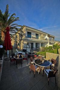 a patio with tables and chairs and a building at Apartments Bozikovic in Podstrana