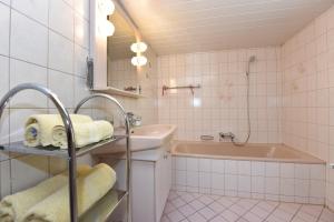 uma casa de banho com uma banheira e um lavatório e uma banheira em Haus Brügga em Brand