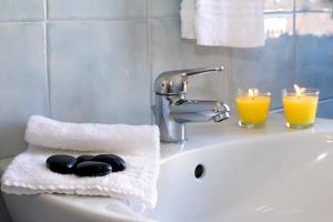 a bathroom sink with two candles and a towel at Residence Teclini in Castiglione della Pescaia