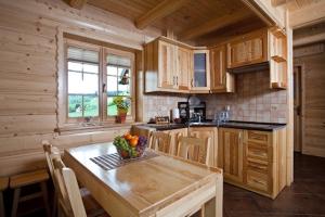 a kitchen with a table with a bowl of fruit on it at Luxdomki in Szczawnica