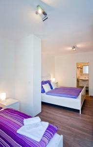 2 Betten in einem Zimmer mit lila Bettwäsche in der Unterkunft Bed & Breakfast BonnaNotte in Essen