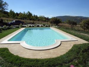a swimming pool in a yard with a car in the background at Al Castello in San Severino Marche +9 photos