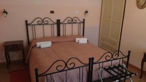 ベネヴェントにあるB&B Le Stanze del Sognoのベッドルーム1室(黒いベッド1台、枕2つ付)