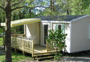 une petite maison avec une terrasse couverte et une terrasse dans l'établissement Camping du petit vaux Chez Camille, à Veynes