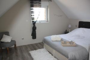 ein Schlafzimmer mit einem Bett, einem Stuhl und einem Fenster in der Unterkunft Comme un Rêve in Doignies