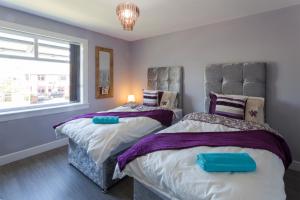a bedroom with two beds and a window at Central Ayr Main Road Apartment in Ayr