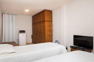 1 dormitorio con 2 camas, TV y armario en Praia Copacabana, en Río de Janeiro