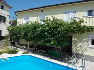a villa with a swimming pool in front of a house at Aurelia Apartment in Ližnjan