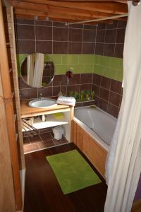 La salle de bains est pourvue d'une baignoire, d'un lavabo et d'un miroir. dans l'établissement Brindepaille, à Vallon-Pont-dʼArc