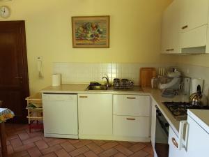 モンテ・サン・サヴィーノにあるVilla La Torricellaの白いキャビネットとシンク付きのキッチン