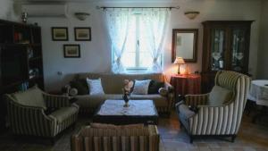 een woonkamer met een bank, 2 stoelen en een tafel bij Lake house Puro in Dodoši