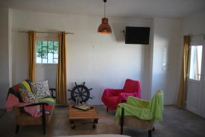 a living room with two chairs and a tv at Casa do Loureiro Branco in Santarém