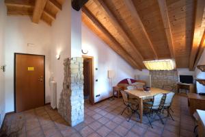 - un salon avec un plafond en bois, une table et des chaises dans l'établissement Residence Villa Nicole, à Arco