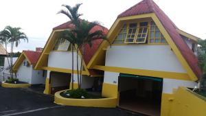 a yellow and white building with palm trees at Motel dos Arcos (Adult Only) in Porto Alegre